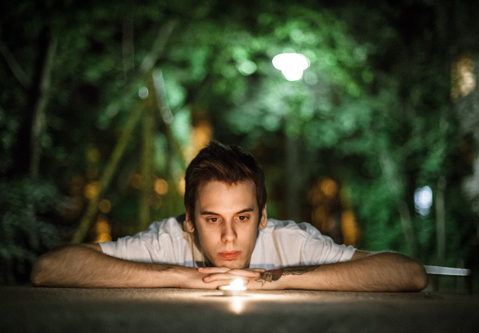 man relaxing while staring at a candle